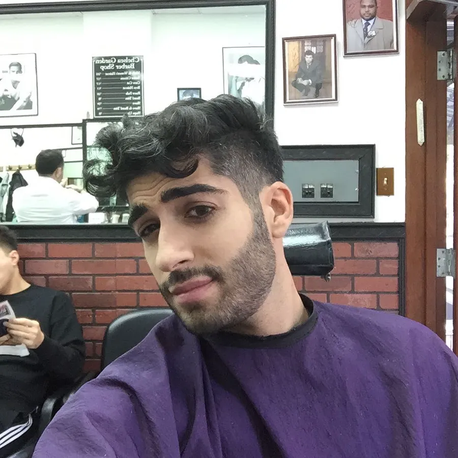 Curly pompadour with a tapered fade in the chair at Chelsea Gardens