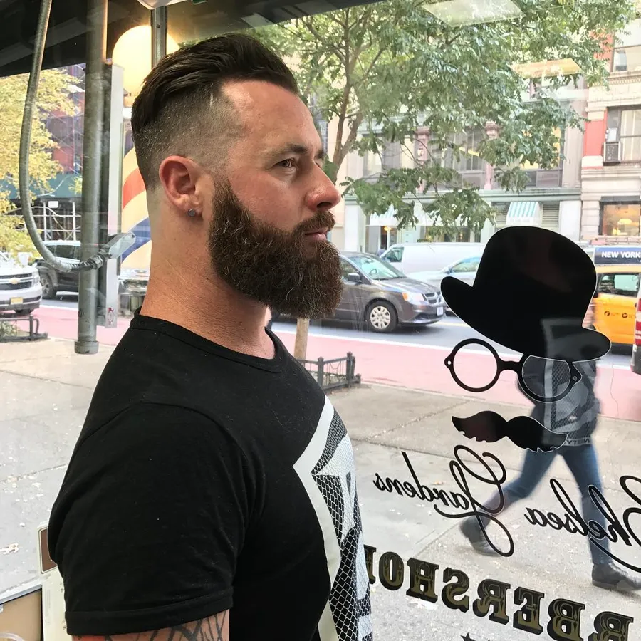 Disconnected undercut and full beard outside the gold-leaf shop window